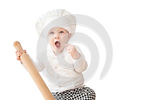 Baby boy, child in chef costume cook with rolling pin. Positive