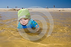 Baby boy child swimming in fun beach water photo