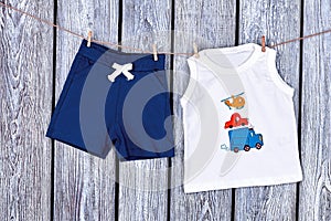 Baby boy clothes hanging on rope.