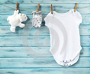 Baby boy clothes and white bear toy on a clothesline photo