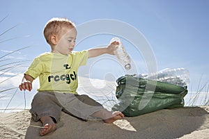 Baby Boy Collecting Bottle In Plastic Bag On Beach