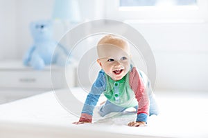 Baby boy crawling on bed