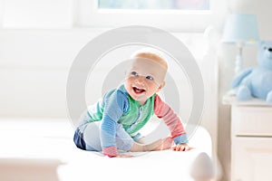 Baby boy crawling on bed