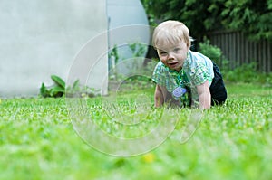 Baby boy crawling on the grass