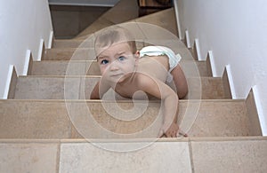 Baby boy crawling up the stairs