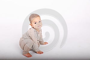 Baby boy in cream clothes on white