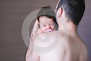 Baby boy crying on his father shoulder