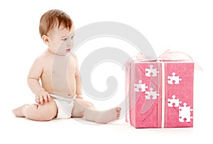Baby boy in diaper with big puzzle gift box