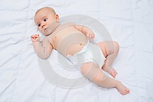 baby boy in a diaper lying on a crib on a white background.