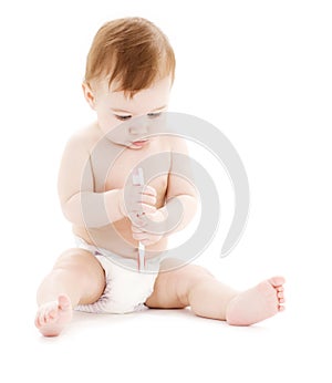 Baby boy in diaper with toothbrush