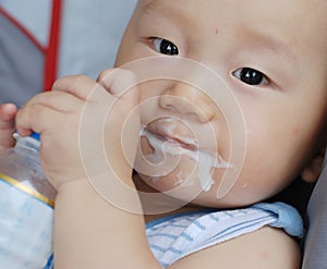 Baby boy eating acidophilus milk photo