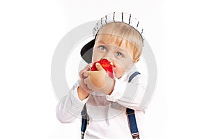 Baby boy eating apple and smiling in the studio isolated on white background