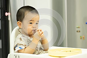 Baby boy eating by his hand with dirty face