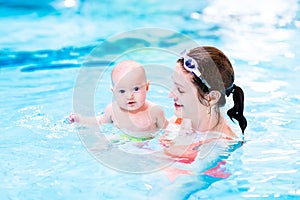 Baby boy enjoying swimming lesson in pool with mother