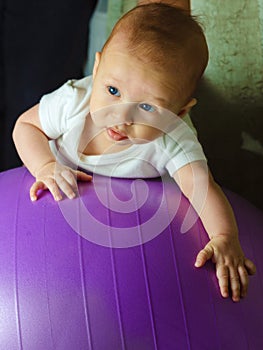 Baby boy is exercising on gymnastic ball