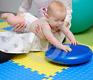 Baby boy getting massage with special equipment