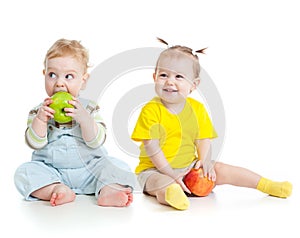 Baby boy and girl eating apples isolated