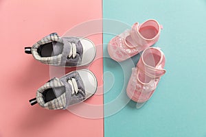 Baby boy and girl shoes on pastel colors background