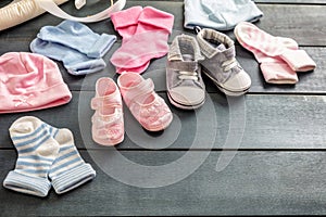 Baby boy and girl shoes and socks on blue wooden background