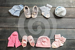 Baby boy and girl shoes and socks on blue wooden background