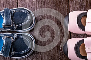 Baby boy and girl shoes on wooden background. Child footwear. Top view.