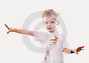 The baby boy with gouache soiled hands and shirt isolated