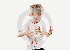 The baby boy with gouache soiled hands and shirt isolated