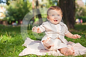 Baby boy on grass in park.