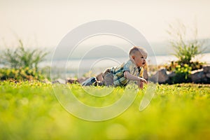 Baby boy on green grass nature background