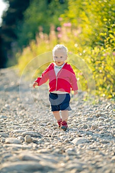 Baby boy hiking on dirt road in forest