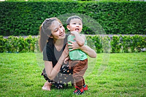 Baby boy with his mum in the park.