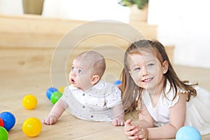 Baby boy and his sister playing with balls. Colorful toys for kids. Kids in play room