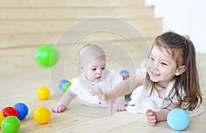 Baby boy and his sister playing with balls. Colorful toys for kids. Kids in play room