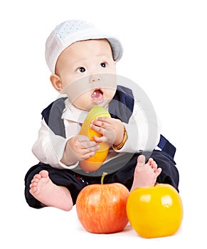 Baby boy holding fruits.