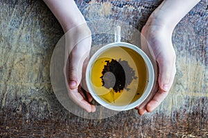 Baby boy holds cup of tea