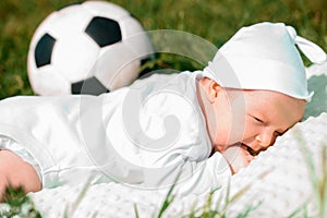Baby boy infant fun photoshoot soccer football concept big smile having fun playing laughing laying on white furry round through s