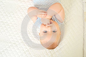 Baby boy looking into the eyes while lying on a white background