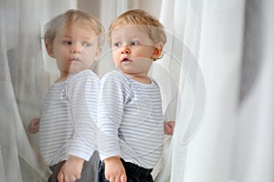Baby boy looking at himself in reflection