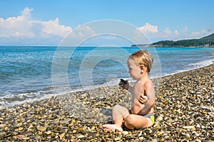 Baby boy in lotus pose on beach
