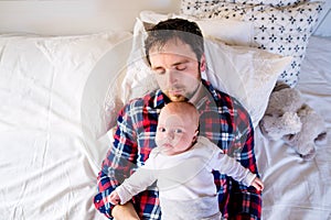 Baby boy lying on bed with his father