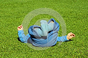 Baby boy lying on a grass in a park