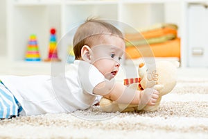 Baby boy lying with plush toy