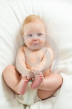 Baby boy lying on white sheet