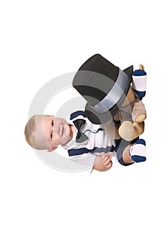 Baby boy magician hiding soft toy under cylinder