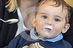 Baby boy with milk mustache making funny faces