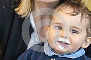 Baby boy with milk mustache making funny faces