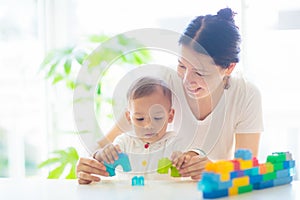 Baby boy and mother playing with toy