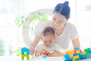 Baby boy and mother playing with toy