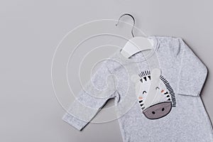 Baby boy newborn bodysuit with cute zebra face on beige background. Children& x27;s clothes. Fashion outfit. Flat lay