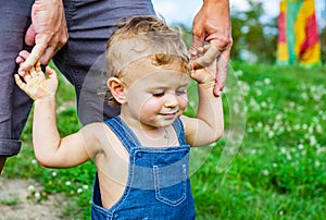 Baby Boy in park. trust family hands of child son and father